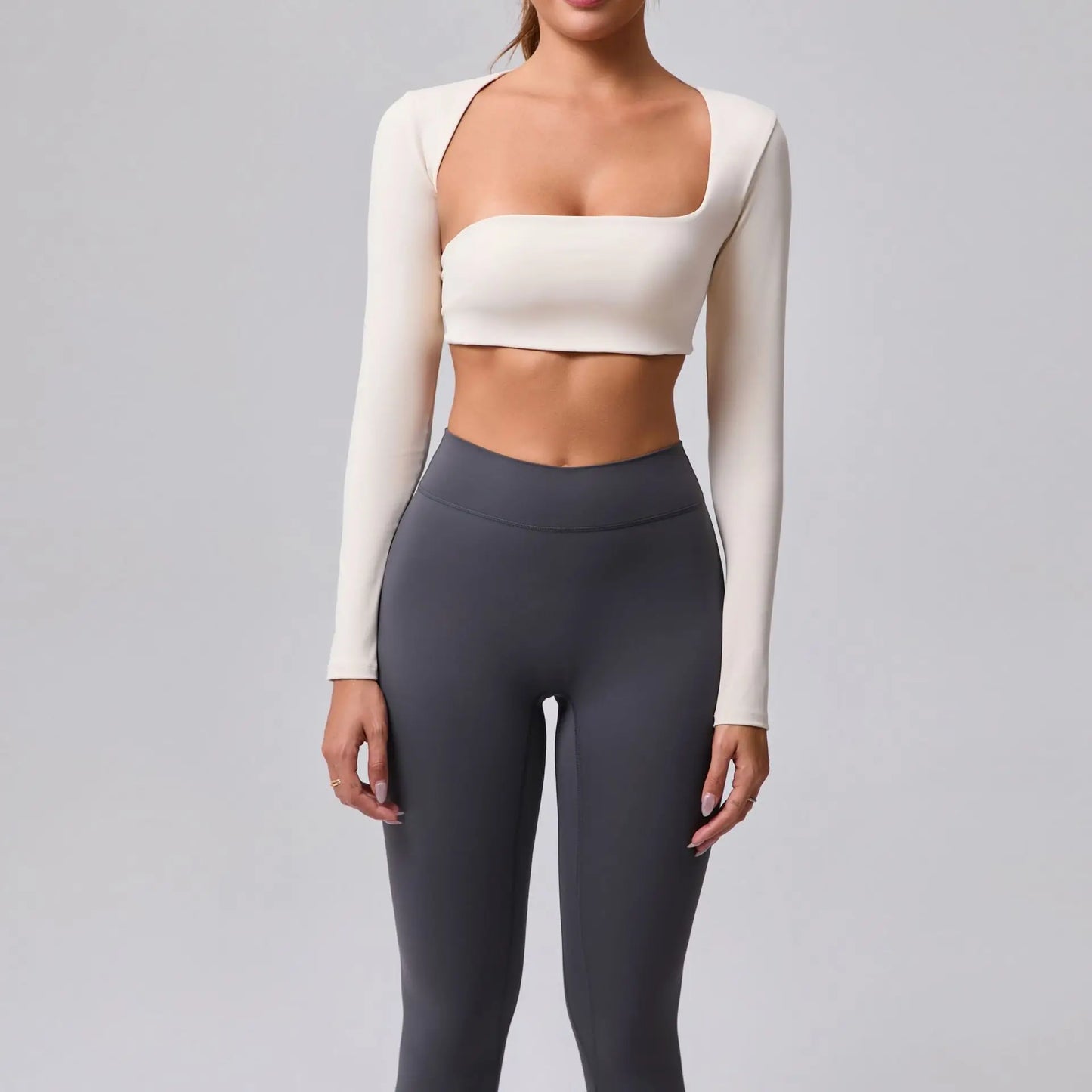Women's sports crop top with square neckline, asymmetric long sleeve, and quick-drying fabric.
